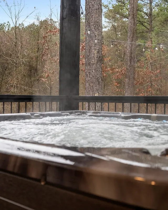 Private hot tub on the covered deck looking into the pines