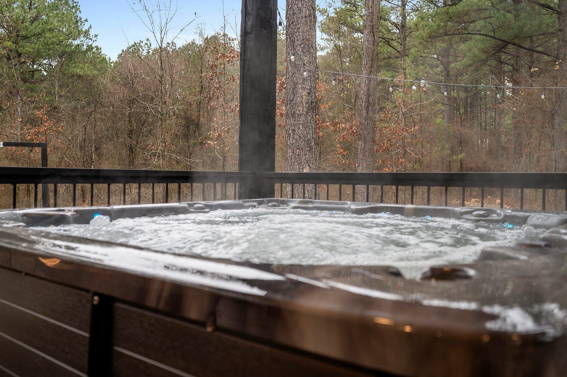 Private hot tub on the covered deck looking out into the pine forest