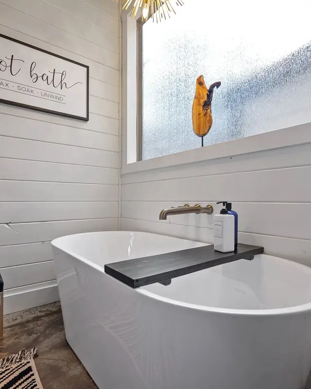 Freestanding soaking tub below a frosted window